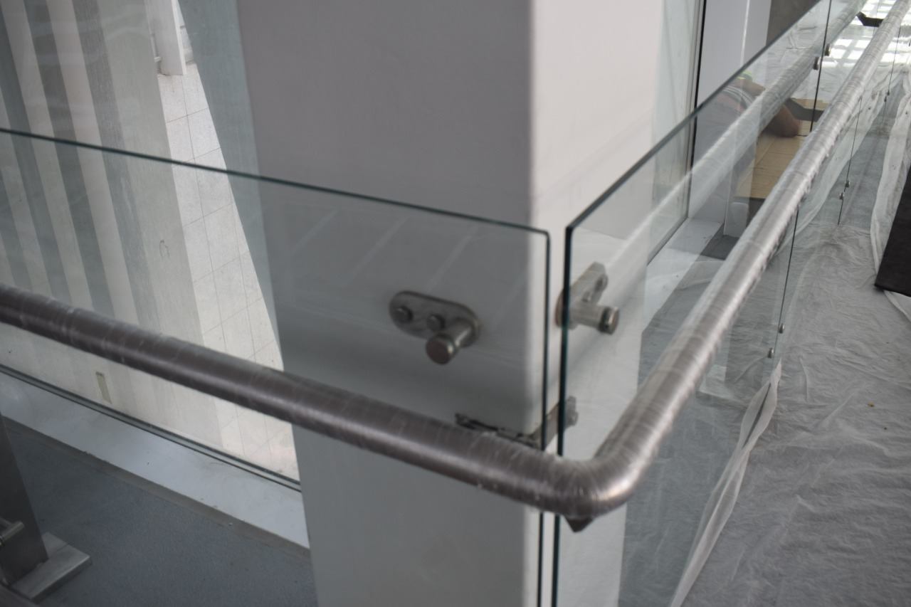 A handrail bracket fixed through the glass