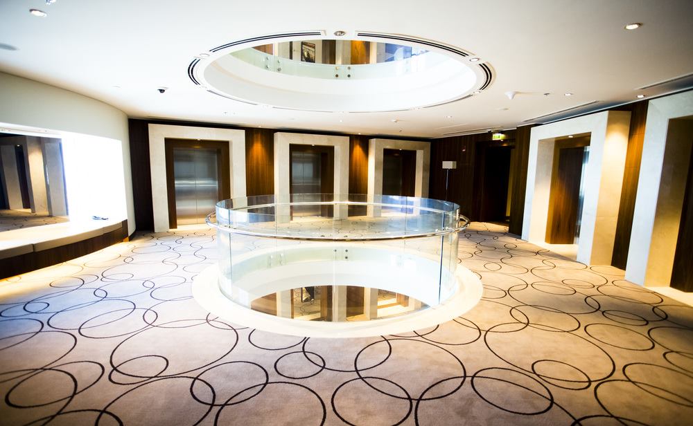A curved glass handrail around a round atrium
