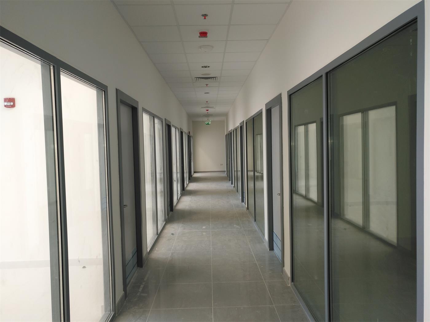 A corridor with glass office fronts