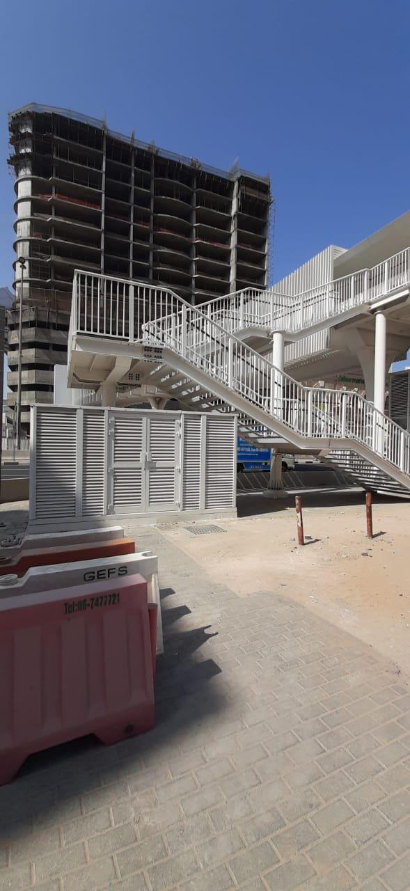 A pedestrian bridge stair with a louvered enclosure