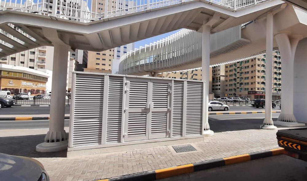 A louvered enclosure below a pedestrian bridge in Sharjah
