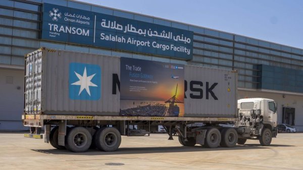 Glass curtain wall of the Salalah Airport Cargo Facility, with a truck in front