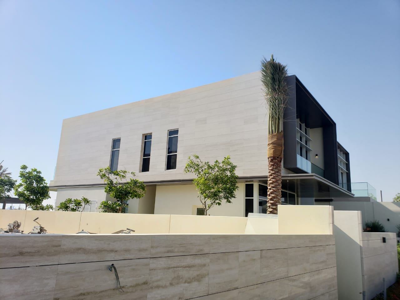 A villa with a dark ACP volume and glass balconies